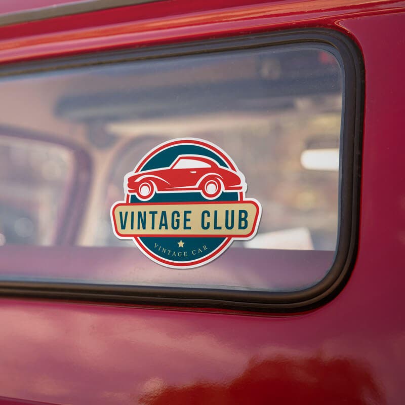 Vintage-style car window with a 'Vintage Club' sticker featuring a red classic car and bold retro typography.